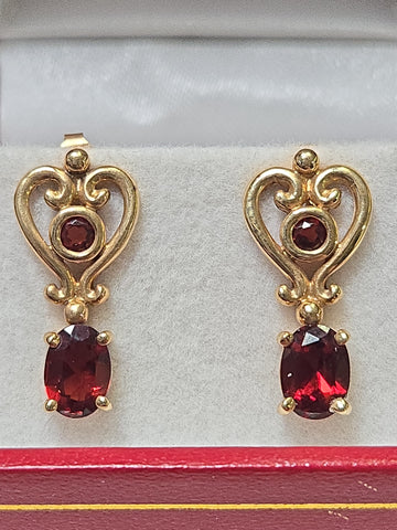 14K gold drop earrings with 2ct oval garnets, featuring elegant design and sparkling gemstone accents by Chique Jewelry.