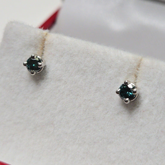 14K white gold stud earrings with 0.1ct round treated blue diamonds from Chique Jewelry, lightweight and elegant accessory.