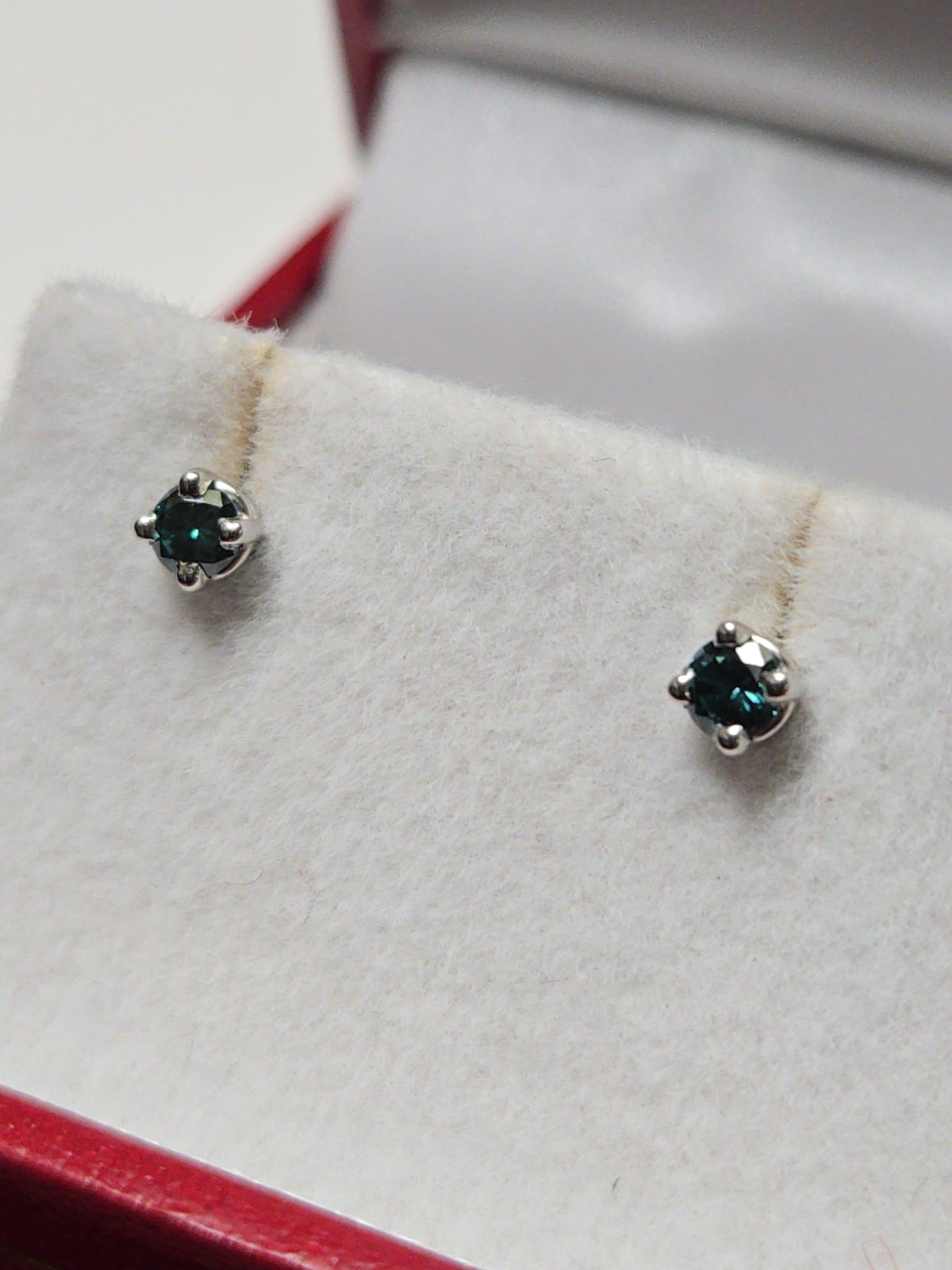 14K white gold stud earrings with 0.1ct round treated blue diamonds from Chique Jewelry, lightweight and elegant accessory.