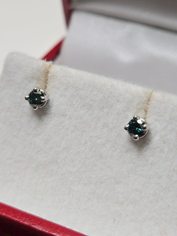 14K white gold stud earrings with 0.1ct round treated blue diamonds from Chique Jewelry, lightweight and elegant accessory.