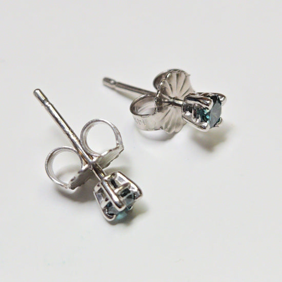 14K white gold stud earrings featuring 0.1ct round treated blue diamond, from Chique Jewelry.