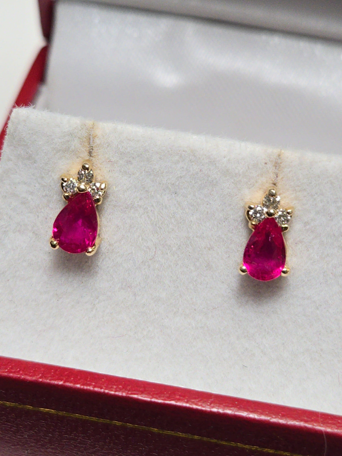 14K gold stud earrings featuring a 0.9ct pear-shaped ruby, crafted by Chique Jewelry, displayed on a clean background.