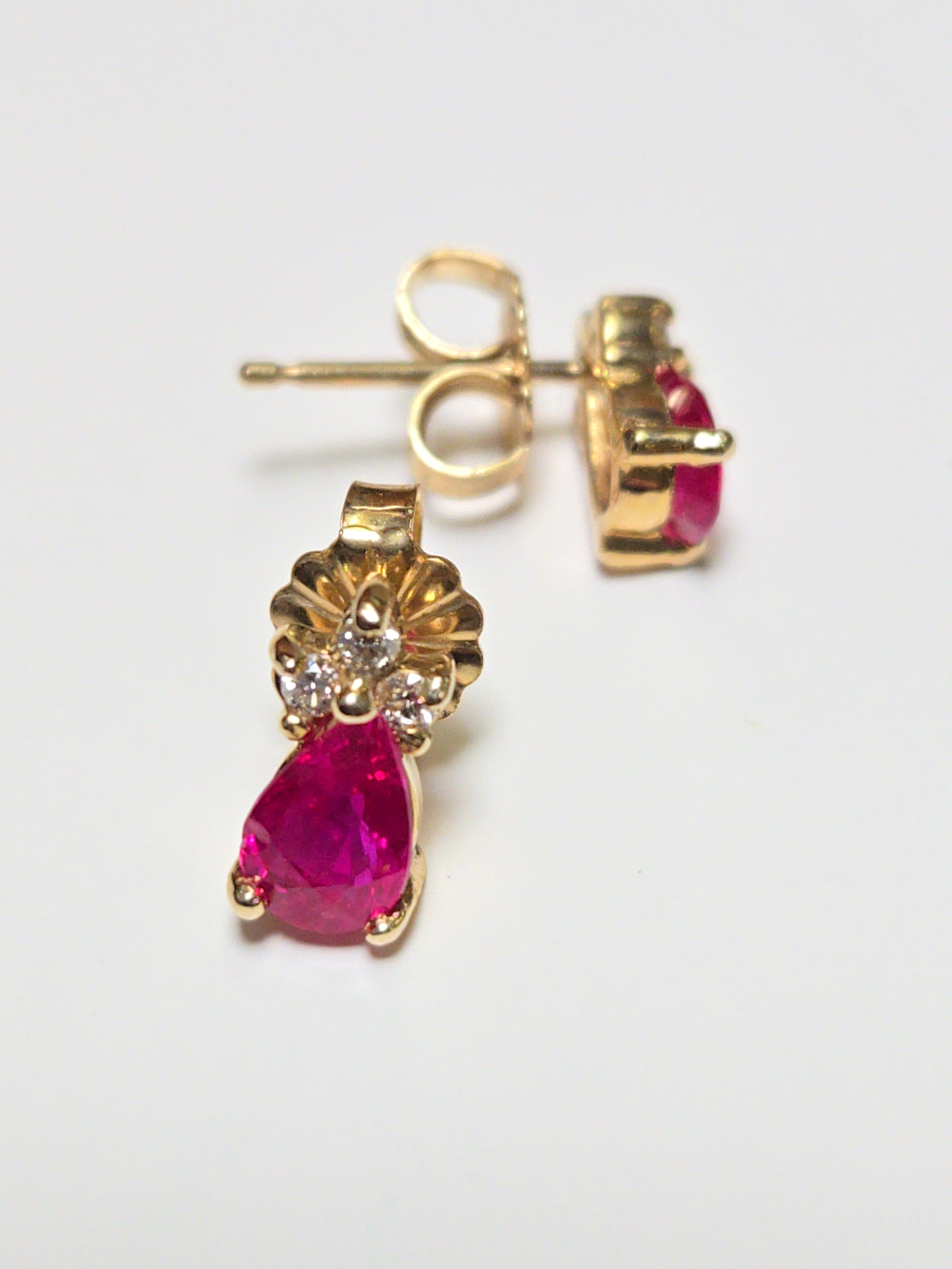 14K gold stud earrings featuring 0.9ct pear-shaped ruby gemstones, crafted by Chique Jewelry.