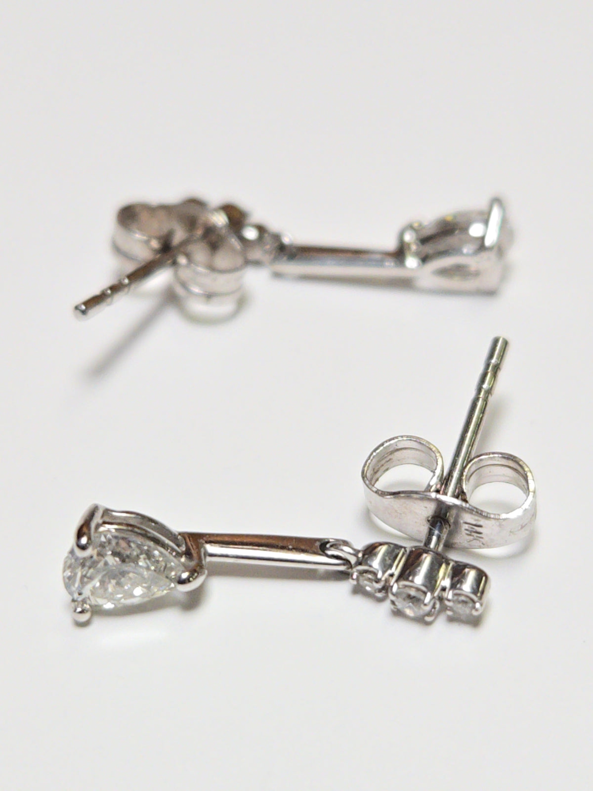 14K white gold drop earrings with 0.38ct pear-shaped diamond, featuring elegant jewelry design and shimmering brilliance.