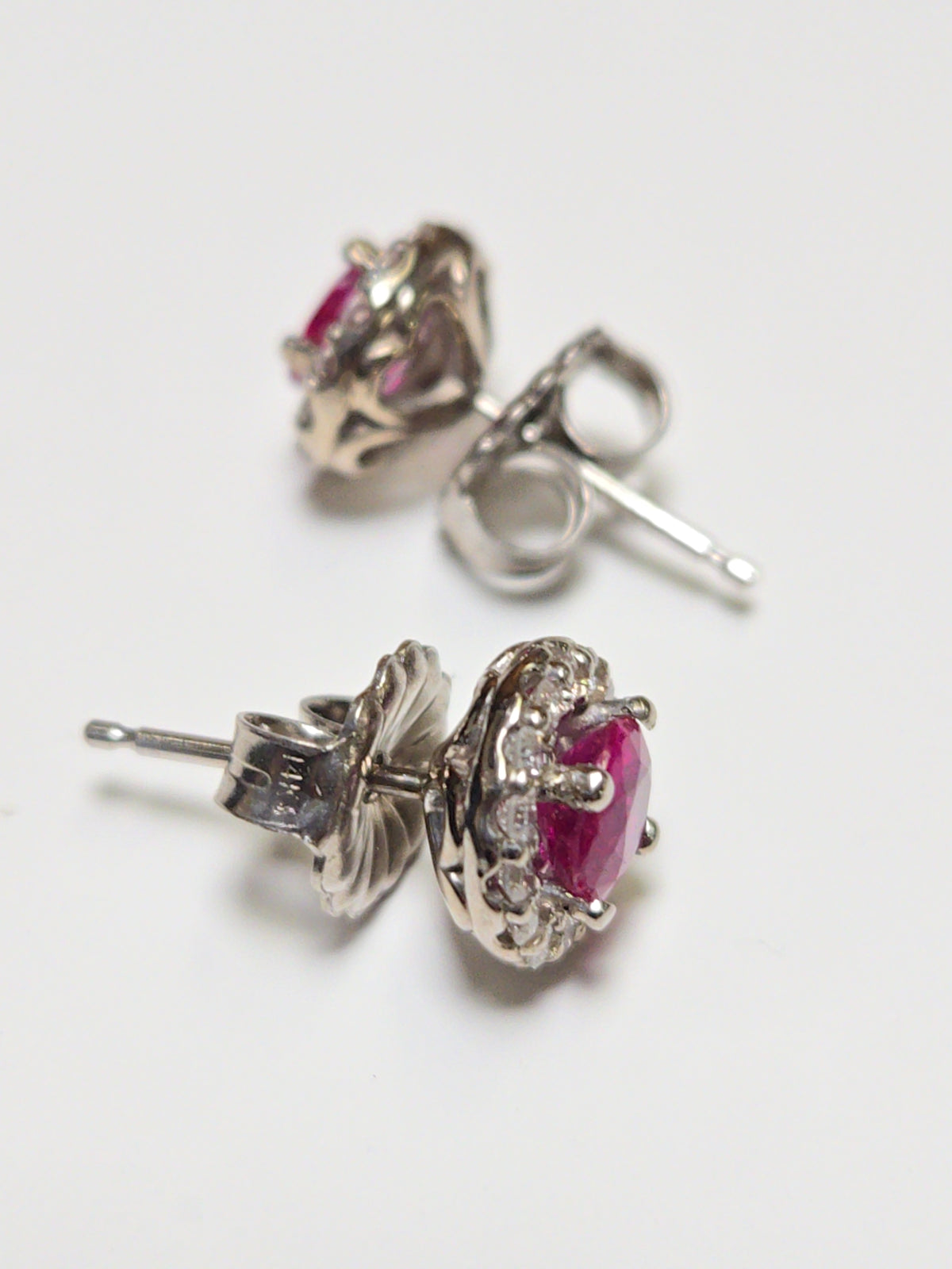 14K white gold two-stone stud earrings with 0.97ct round rubies from Chique Jewelry, featuring a sleek, elegant design.