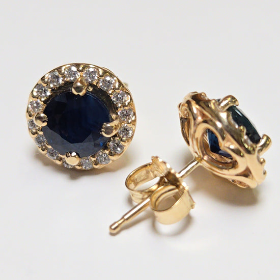 14K gold two-stone stud earrings with 2.45ct round blue sapphires, featuring elegant jewelry design and sparkling gemstones.