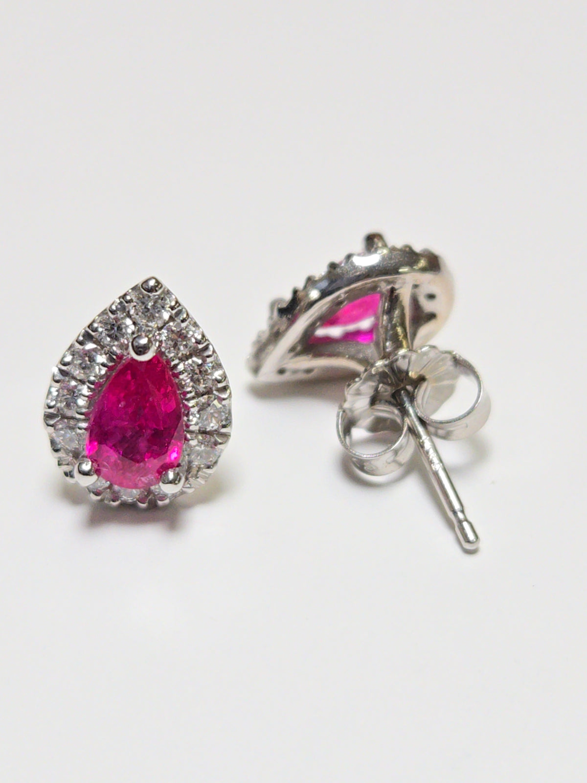 14K white gold two-stone stud earrings featuring 1.02ct pear-shaped ruby gemstones, from Chique Jewelry.