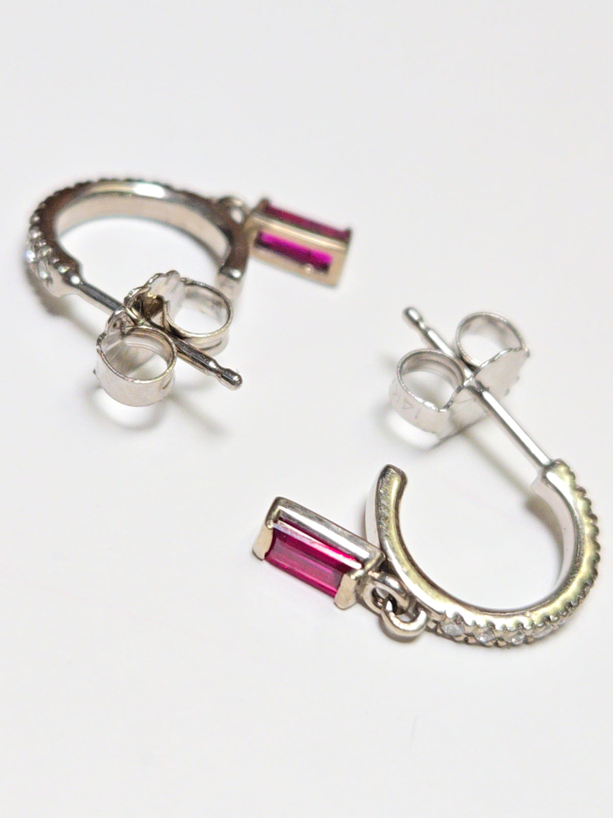 14K white gold hoop earrings with 0.24ct emerald-cut ruby accents, crafted by Chique Jewelry.