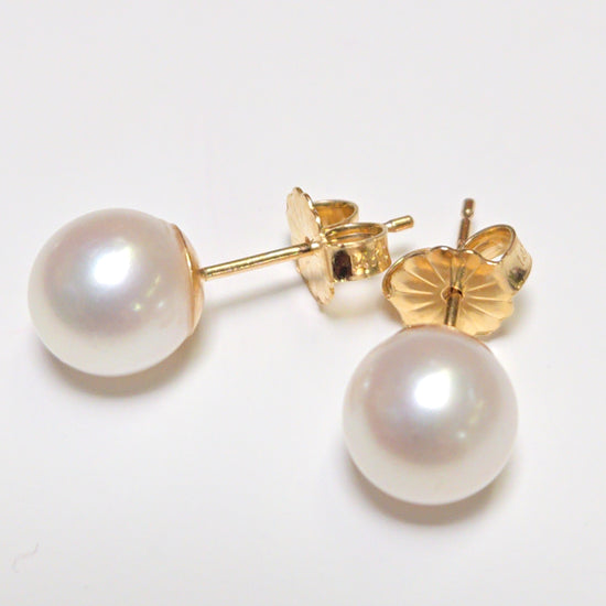 14K gold stud earrings with round pearls from Chique Jewelry, showcasing elegant jewelry with a classic pearl design.