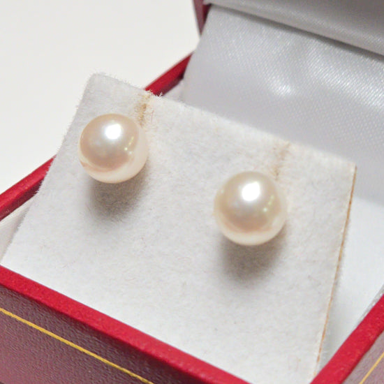 14K gold stud earrings featuring round pearls, weighing 1.5 grams, from Chique Jewelry.