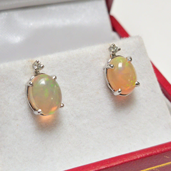 14K white gold stud earrings featuring 1.68ct oval opal gemstones from Chique Jewelry, showcasing elegant jewelry design.