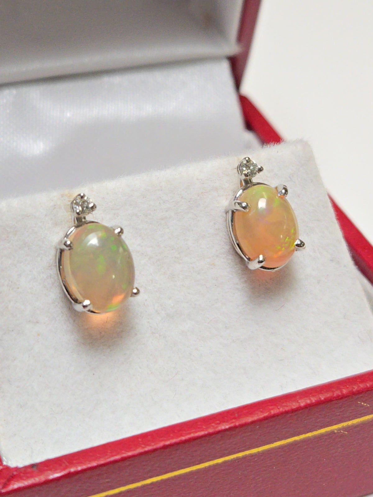 14K white gold stud earrings featuring 1.68ct oval opal gemstones from Chique Jewelry, showcasing elegant jewelry design.