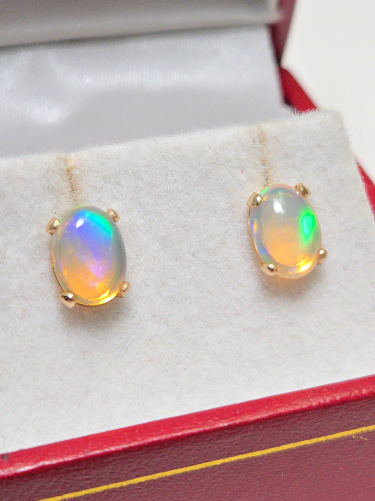 14K gold oval opal stud earrings by Chique Jewelry, showcasing elegant gemstone settings on classic earring designs.