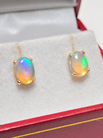 14K gold oval opal stud earrings by Chique Jewelry, showcasing elegant gemstone settings on classic earring designs.