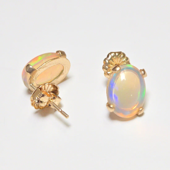 14K gold stud earrings with oval opal gemstones, featuring a simple and elegant design by Chique Jewelry.