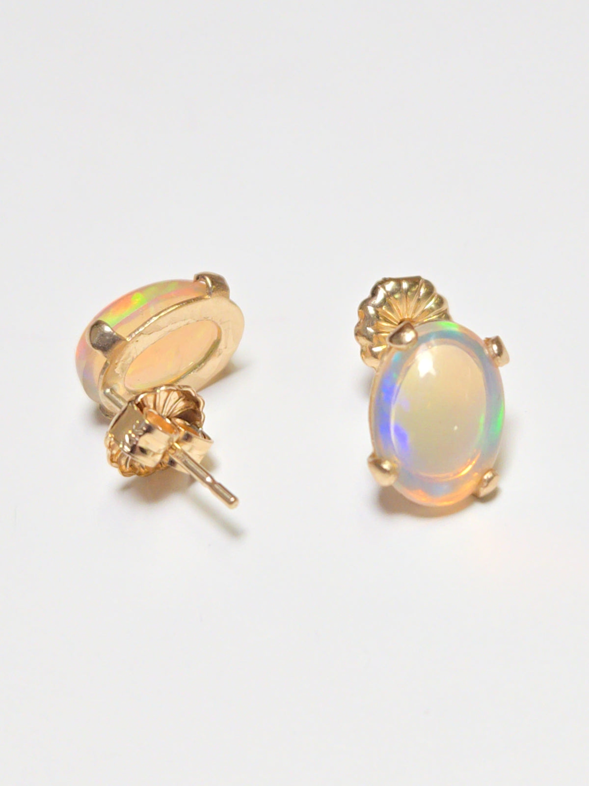 14K gold stud earrings with oval opal gemstones, featuring a simple and elegant design by Chique Jewelry.