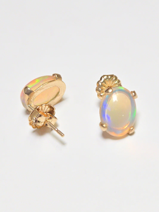 14K gold stud earrings with oval opal gemstones, featuring a simple and elegant design by Chique Jewelry.