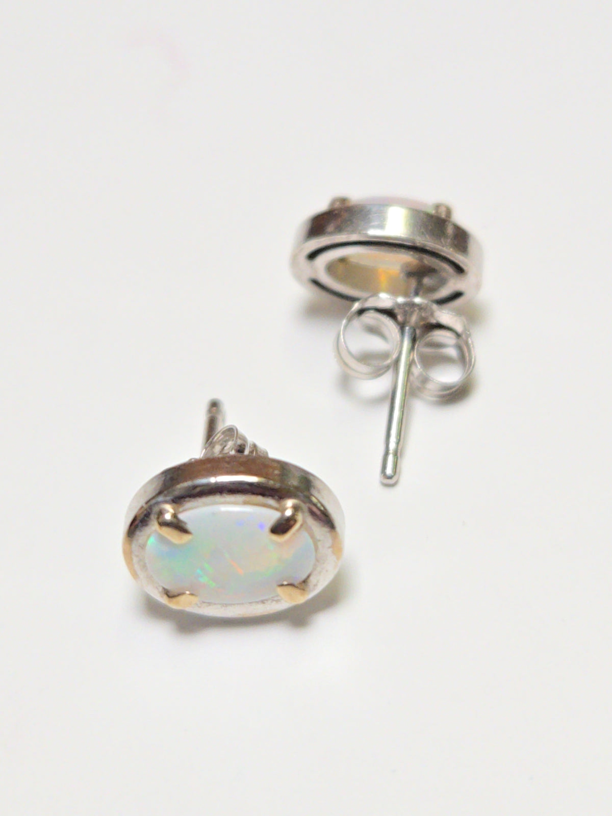 14K white gold oval opal stud earrings from Chique Jewelry, showcasing elegant gemstone settings and polished finish.