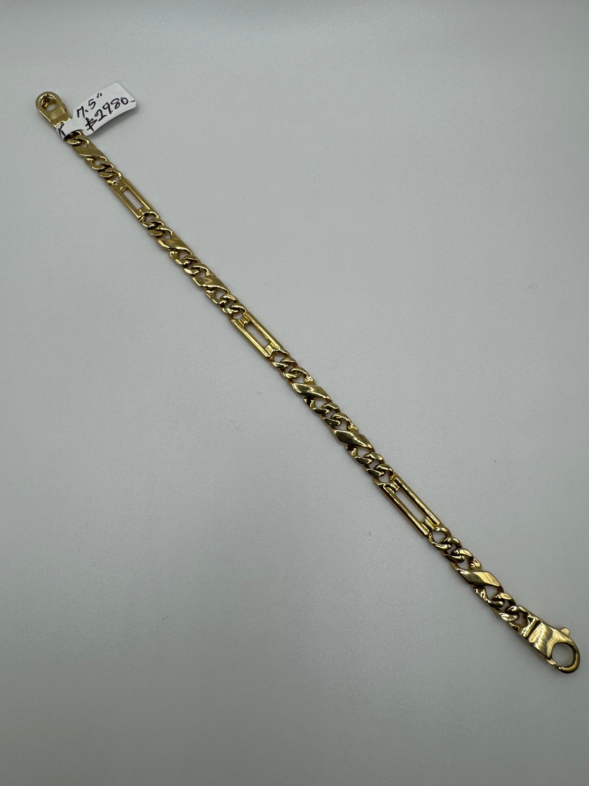 14k gold Figaro bracelet, 7.5 inches long and 4.9mm wide, with a polished finish, weighing 12.3 grams, by Chique Jewelry.