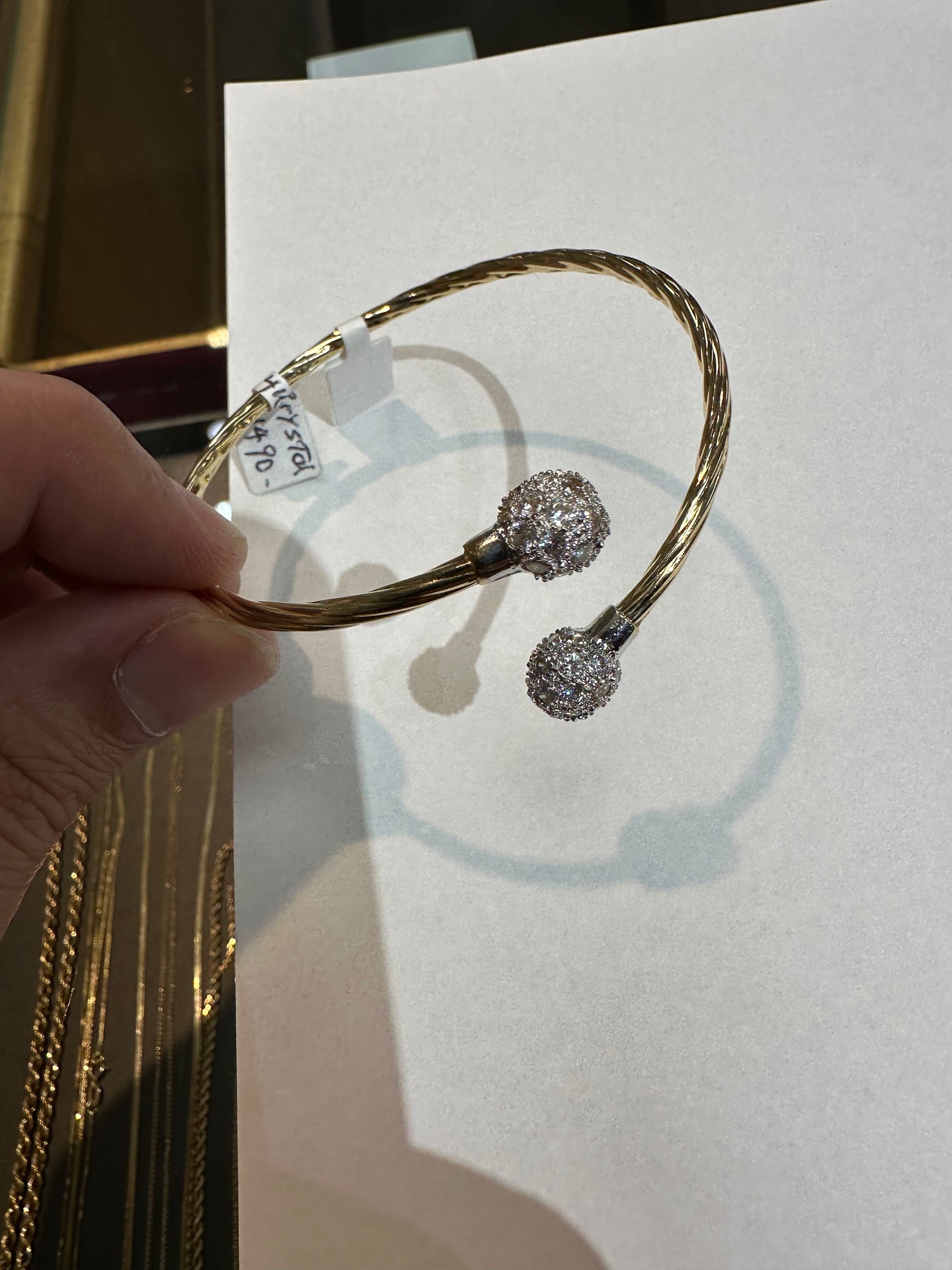 14k gold bangle bracelet with crystal accents from Chique Jewelry, showcasing an elegant and polished design.
